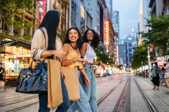 Three women walking down a city street