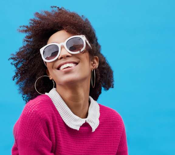 Woman with sunglasses sweater smiling