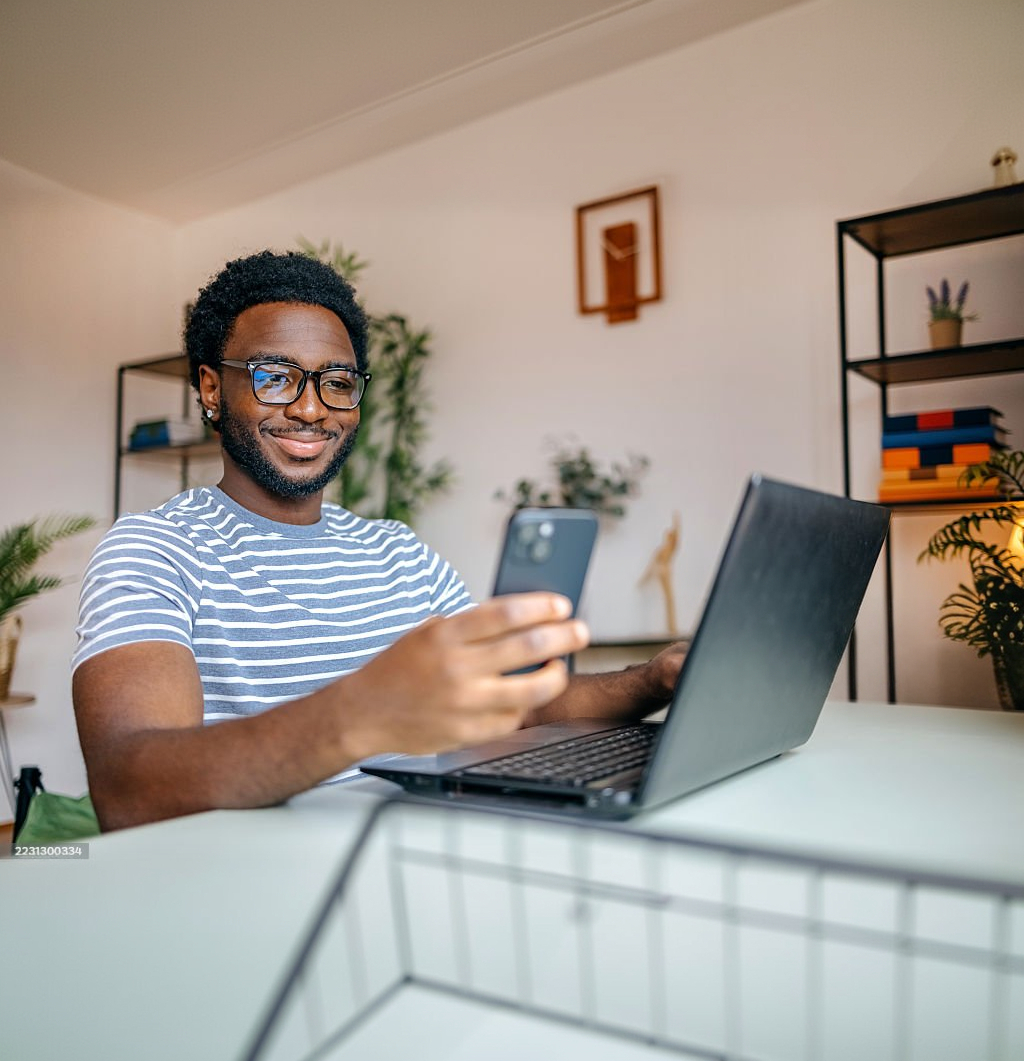 Man looking at phone near computer