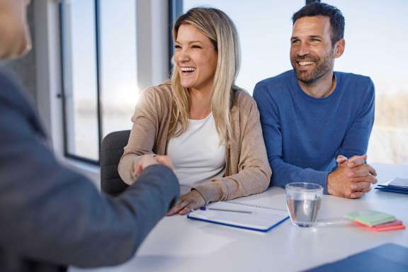 Couple shaking hands with employee