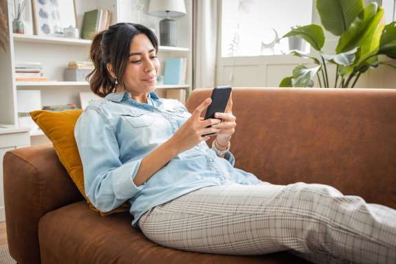 Woman looking at phone on couch